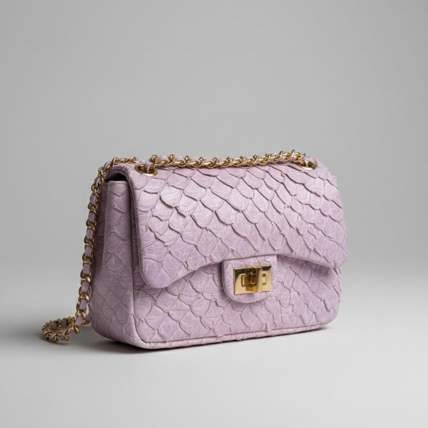 Purple textured handbag with gold chain on a light gray background