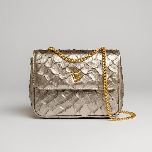 Silver quilted handbag with gold chain on a light gray background